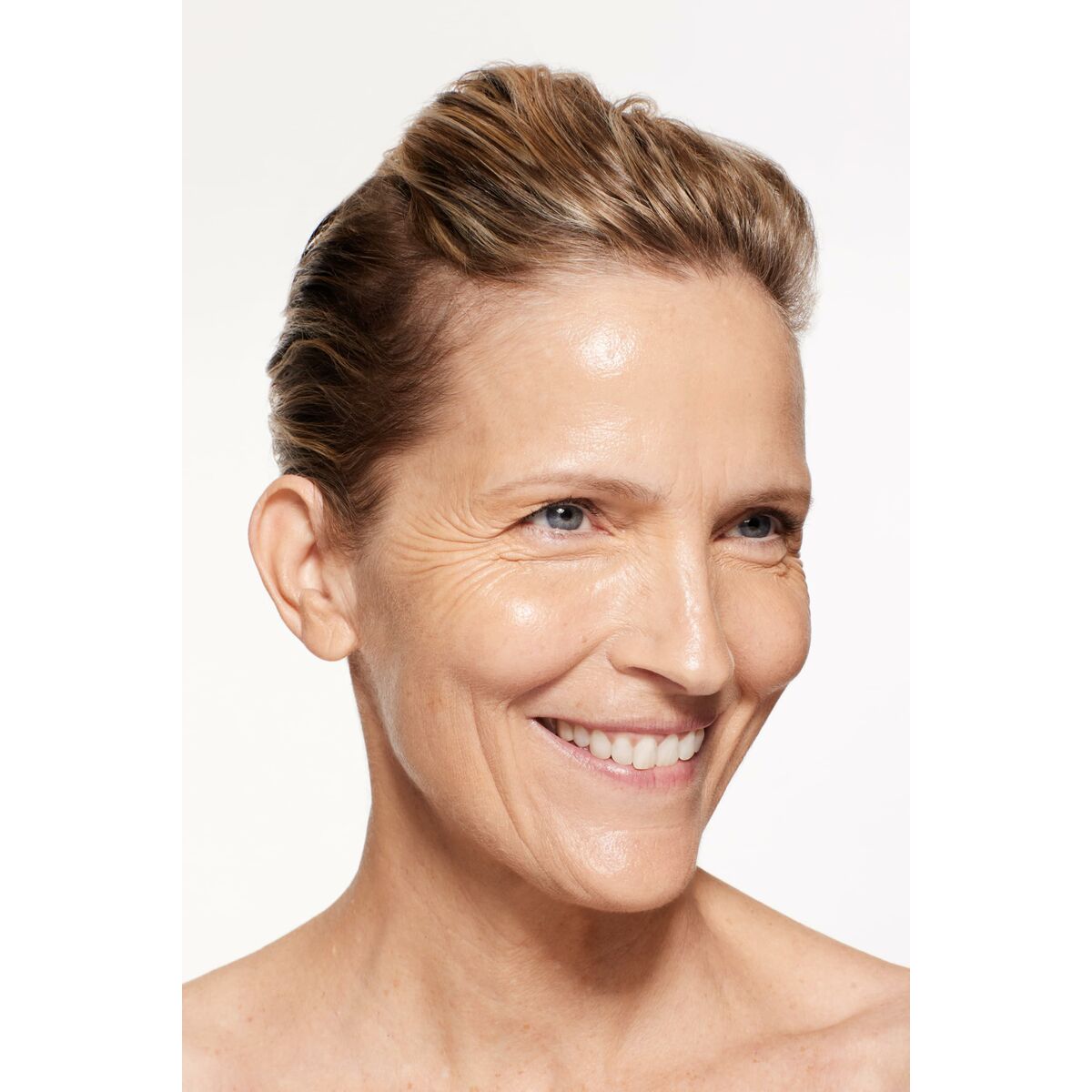 Femme avec peau éclatante et sourire, mettant en valeur un teint naturel et radieux.