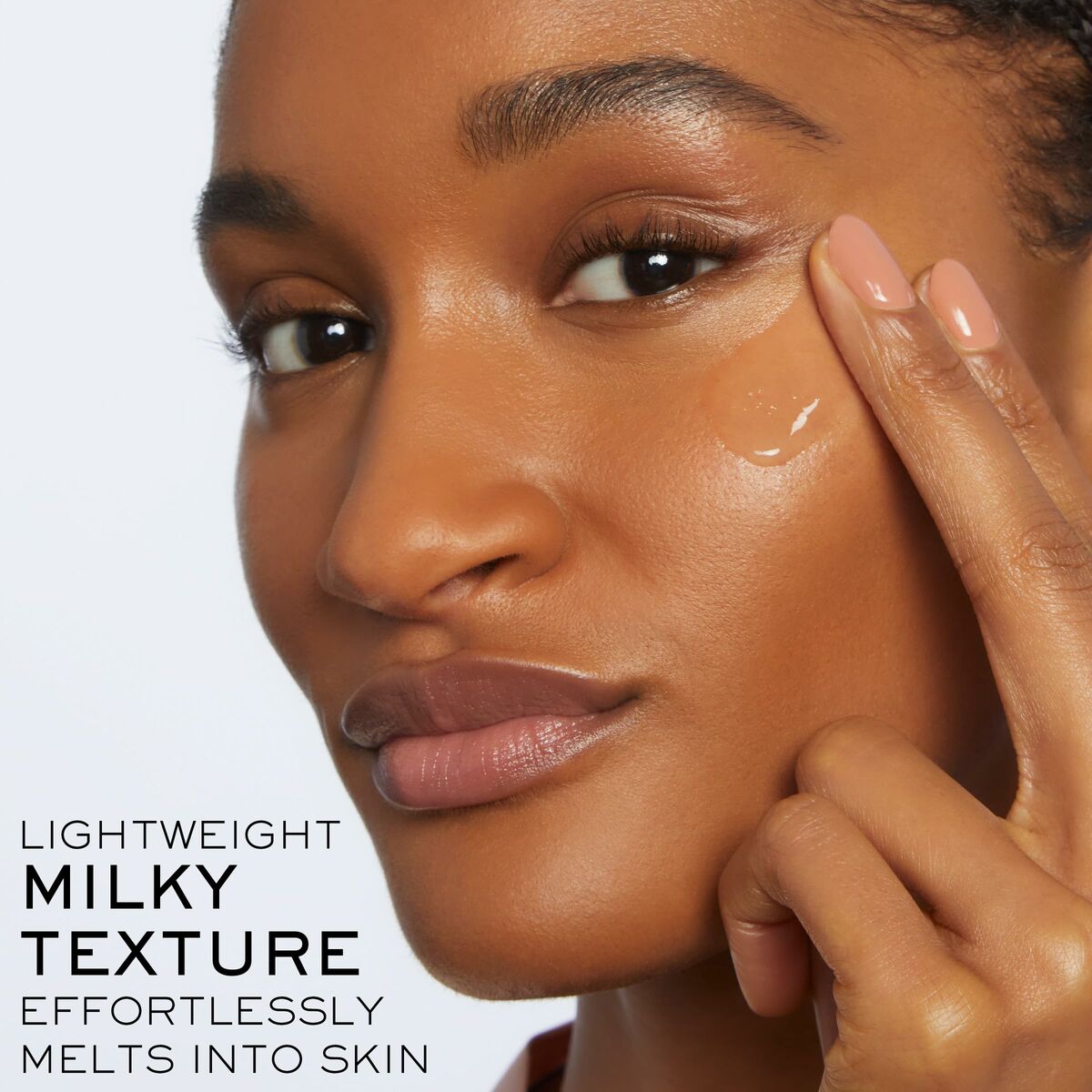 Model applying lightweight milky texture skincare product that effortlessly melts into the skin.