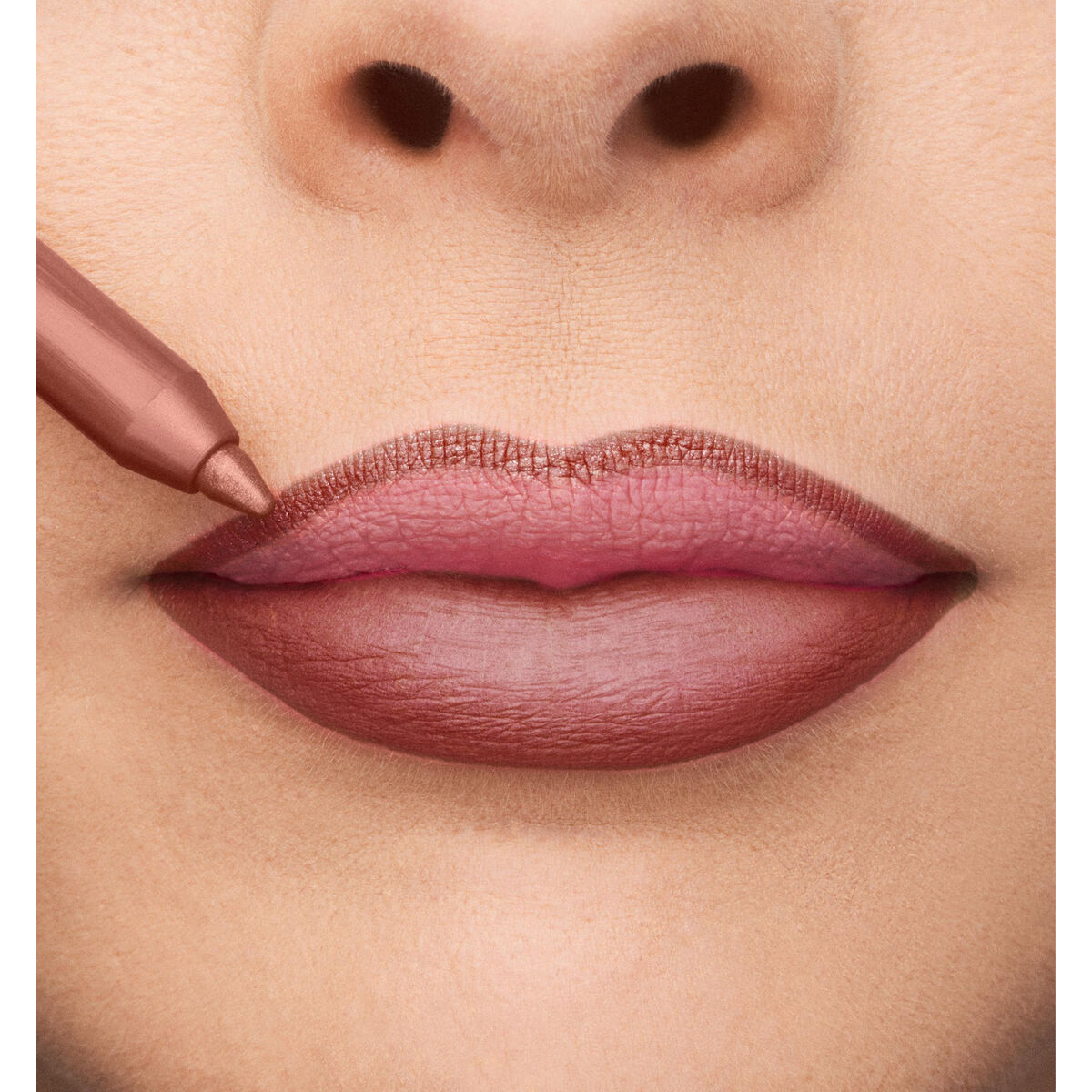 Close-up of lips being outlined with a makeup pencil, showcasing a natural lip color for a polished look.